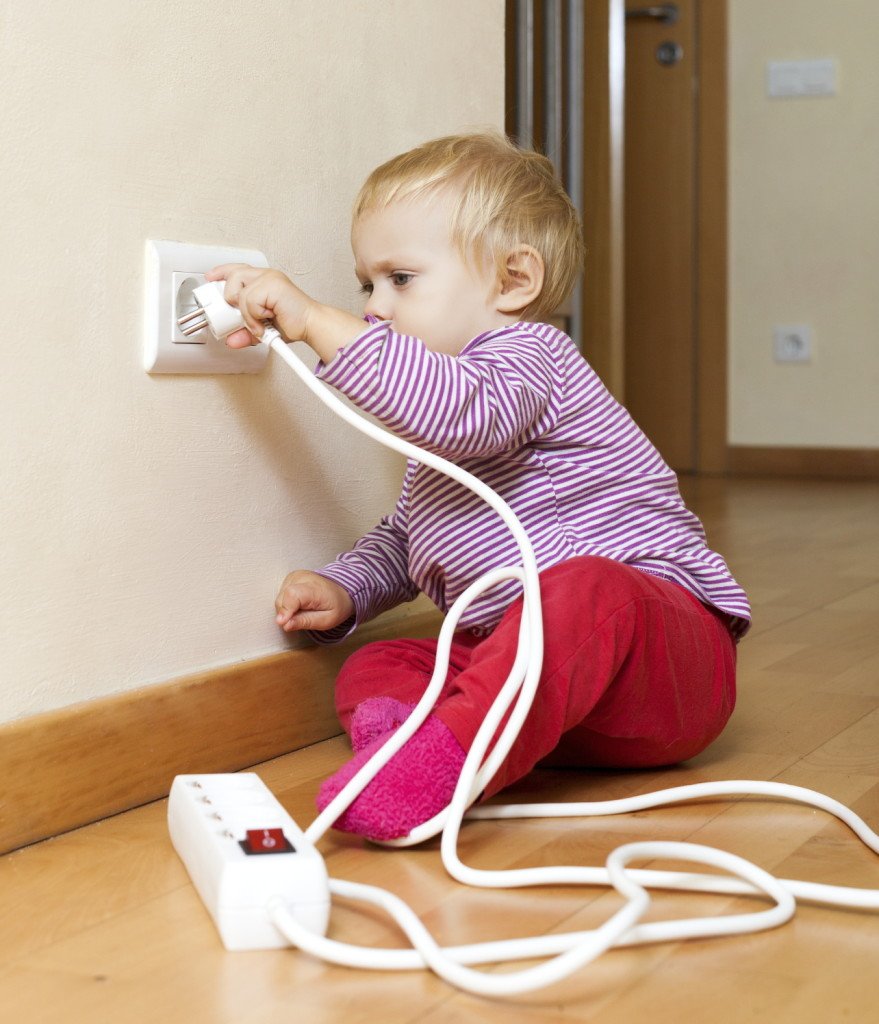 enfant jouant avec une rallonge électrique