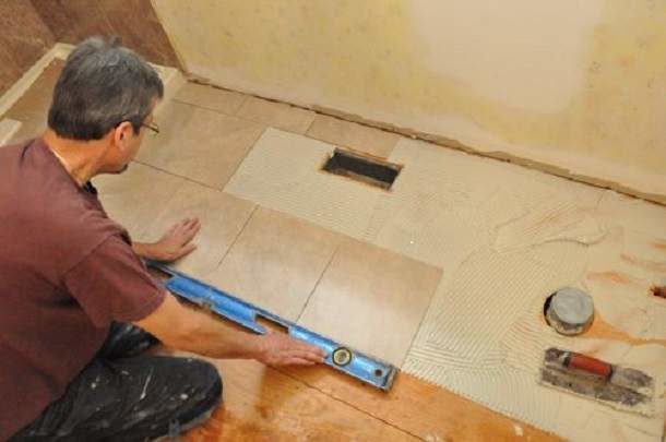 Pose de carrelage sur parquet dans la salle de bain